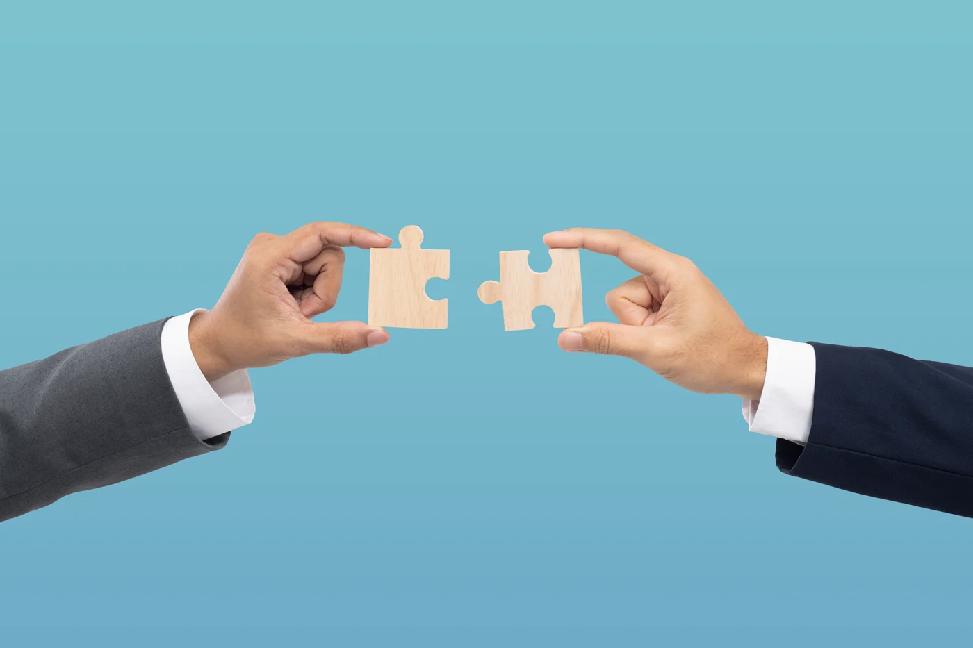Deux mains tenant des pièces de puzzles qui s'emboitent pour montrer les avantages offerts par un cabinet interprofessionnel